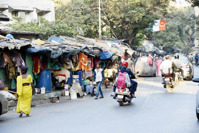 Shanties encroach on a pavement in Mazgaon, forcing pedestrians onto the road. Pic/Pradeep Dhivar