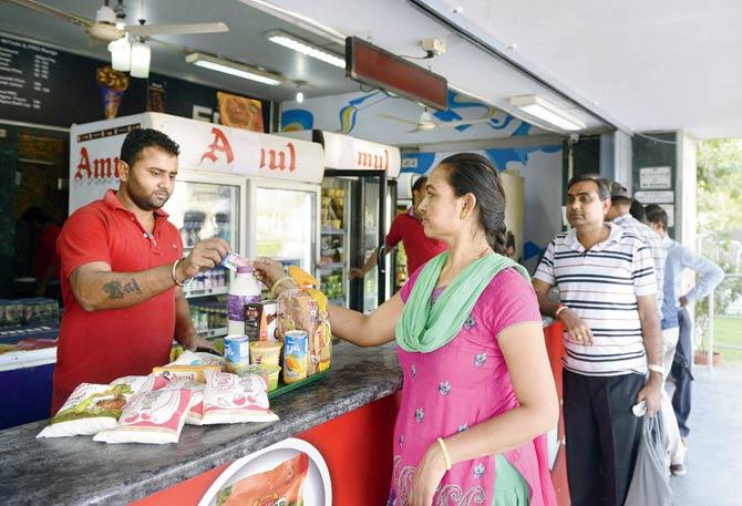 A woman uses a prepaid smart card at a dairy store at Bhatt village in Ahmedabad. Pic/AFP