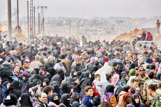 Syrian families queue to get onto governmental buses in the regime-held eastern neighbourhood of Jabal Badro, before heading to government-controlled western Aleppo. pic/afp