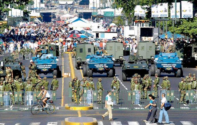 In this February 2004 photo, the military creates a perimeter at a government-subsidised food market in Caracas, Venezuela. Pic/AFP