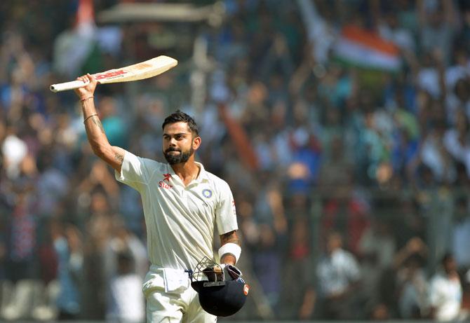 Virat Kohli greets the crowd as he walks back towards the pavilion after his dismissal on the fourth day of the fourth Test cricket match between India and England at the Wankhede stadium in Mumbai on December 11, 2016