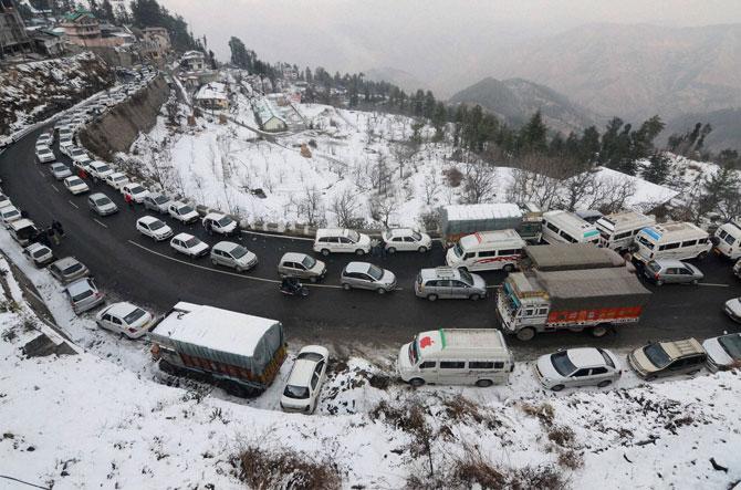 Traffic moves slowly after the first snowfall of the season on Christmas eve, in Shimla on Sunday. PTI 