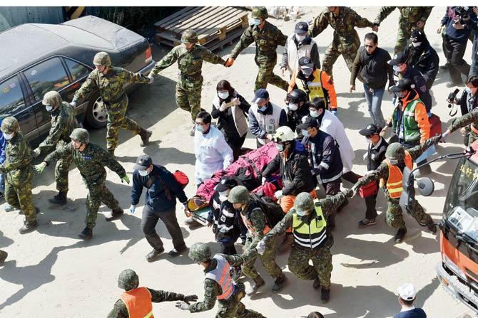 Rescuers carry Li Tsung-tian out of the site of the quake. PIC/AFP