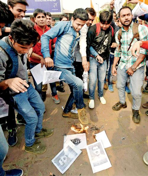 ABVP activists burn and stamp handouts displaying Afzal Guru’s picture in New Delhi yesterday. They were protesting against an event held at JNU supporting the Parliament attack convict. Pic/PTI