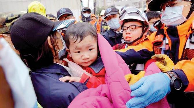 A baby boy is rescued from a collapsed building in Tainan, Taiwan. Pic/AFP