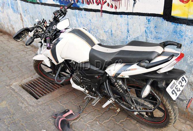 The motorcycle (left) on which Nilesh and Ajay were travelling hit the unmarked speed breaker outside Kalpataru Gardens on Wednesday night. Pics/Nimesh Dave  