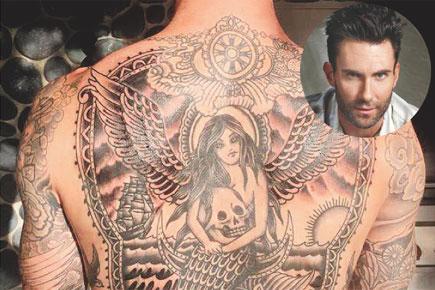 Adam Levine teased fans with a glimpse of his giant back tattoo