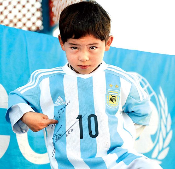 Afghan boy Murtaza Ahmadi shows his jersey sent to him by Lionel Messi. Pic/AFP 