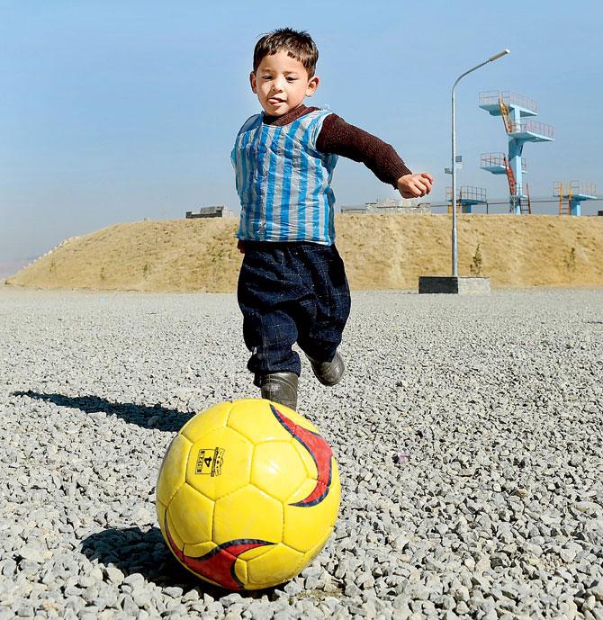Murtaza Ahmadi, a five-year-old Lionel Messi fan, playing  football in Kabul yesterday. Pic/AFP