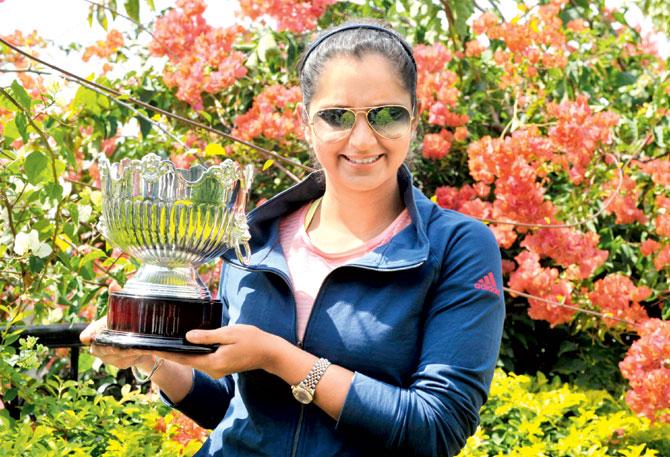 Sania Mirza poses with the Australian Open Trophy at her residence in Hyderabad yesterday. Pic/AFP