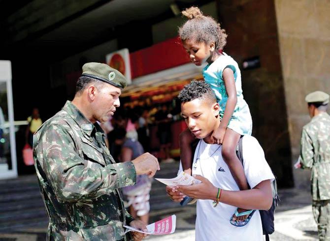 An army soldier interacts with a civilian in Rio de Janeiro. Pic/AFP