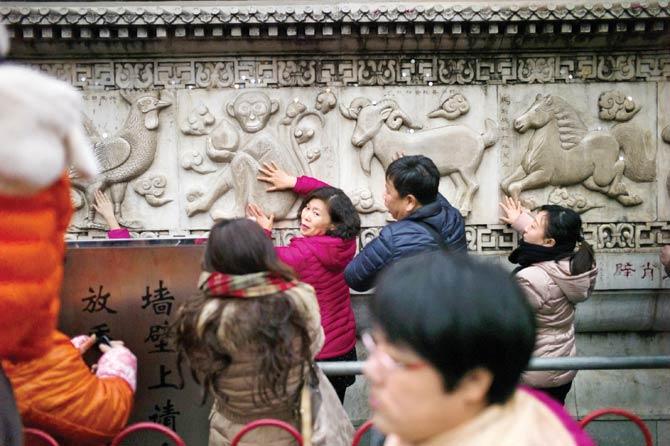 People touch monkey statues for luck at Baiyunguan Temple during Lunar New Year celebrations in Beijing as the Year of the Monkey commenced in China on Wednesday. Pics/AFP