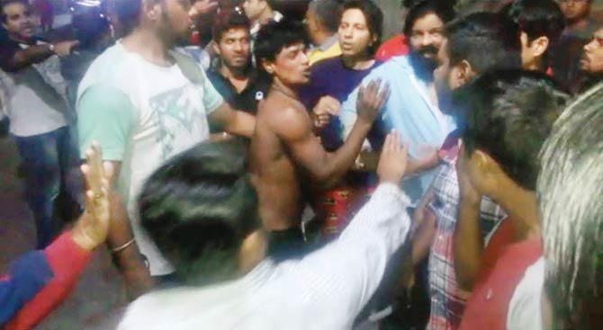 One of the labourers being thrashed by the residents. Pic/Hanif Patel