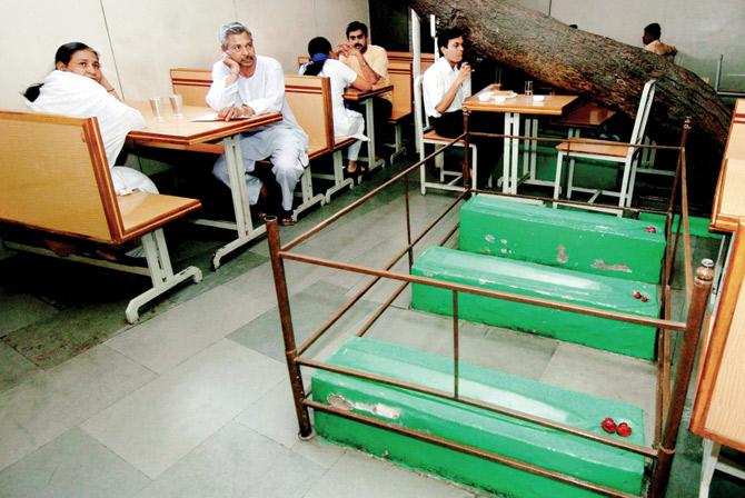 Customers wait for  their orders  next to graves inside Lucky Cafe in Ahmedabad. 