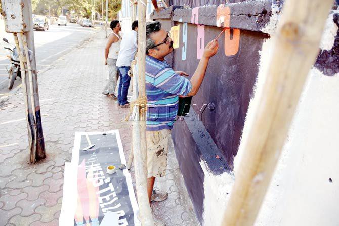 Street artist Ranjit Dahiya readies a wall at Worli Seaface for Make in India. Pic/Atul Kamble
