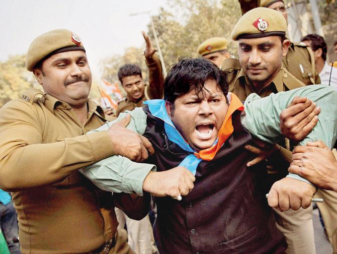 Police detain a member of National Students Union of India during a protest 