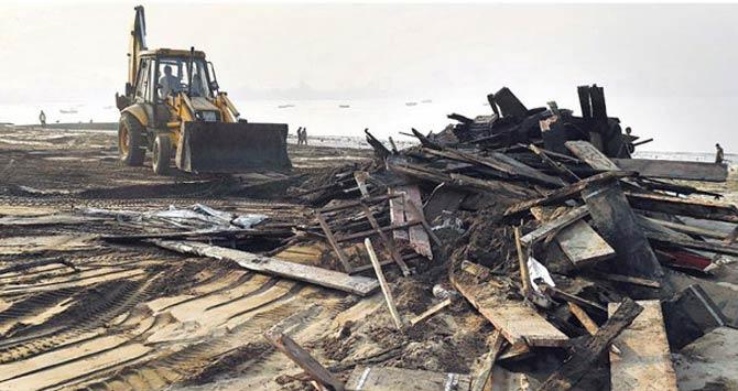 Remains of the day: Debris being removed from Girgaum Chowpatty a day after the fire. Pic/AFP
