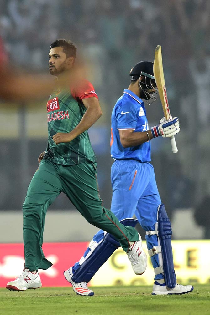 Mashrafe Bin Mortaza (L) celebrates after the dismissal of Indian batsman Virat Kohli 