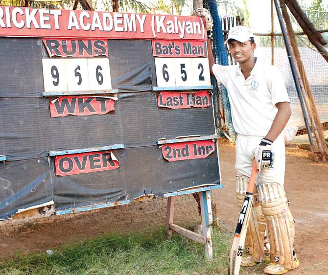 Pranav Dhanawade poses with the scoreboard in Kalyan after ending up with an unbeaten 652