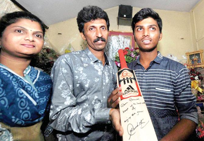 Pranav Dhanawade and his parents pose with the bat autographed by Sachin Tendulkar at their Kalyan residence yesterday