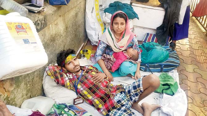 Aslam Shah (35) and his family have been living at the footpath with just a tarpaulin sheet over their heads. The couple is seen here with one of their other children