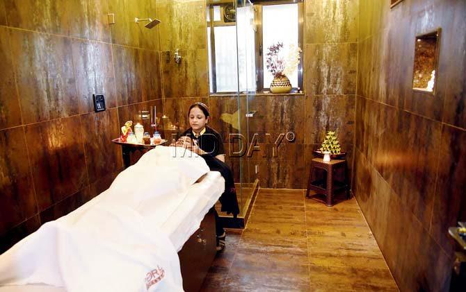 An attendant tends to a client inside the spa room at Chen’s Salon