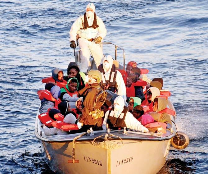 Italian navy ship crewmembers rescue migrants from three dinghies off the Libyan coast in the Mediterranean Sea. Pic/AFP