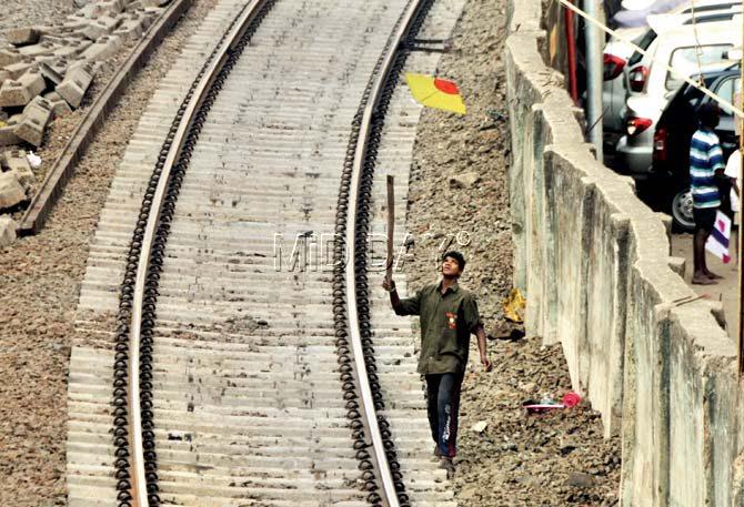 Like a hunter on the prowl, this teenager has his eyes firmly on a dangling kite on the tracks near Charni Road station. Armed with a bamboo stick, he aims for the prize catch