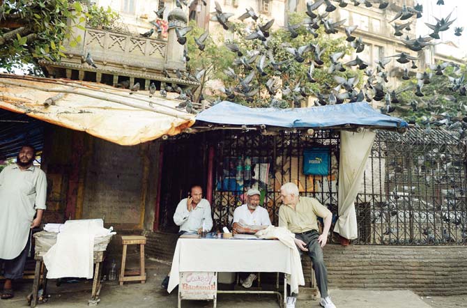 In a photograph from December 2013, a letter writer speaks to a customer at a roadside stall opposite Mumbai GPO. PIC COURTESY/AFP