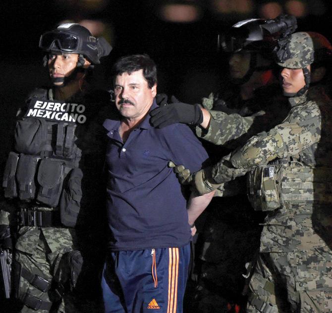The drug kingpin is escorted to a helicopter at Mexico City