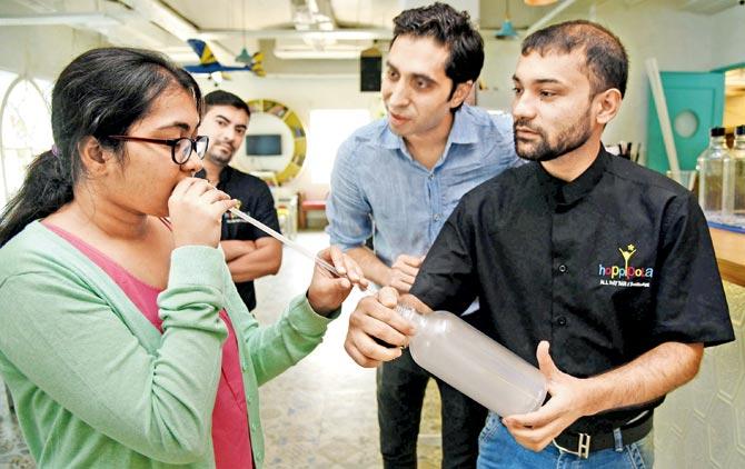 The reporter inhales a vodka vapshot as Sandeep Sharma (second from right) looks on
