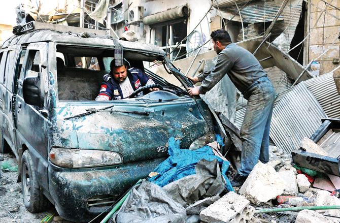 Men inspect a damaged vehicle in the rubble at Aleppo, Syria, on Jan 16. pic/afp