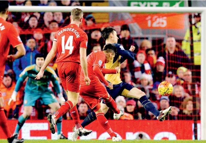 fab firmino: Liverpool’s Roberto Firmino (centre) shoots scores against Arsenal in an EPL tie in Liverpool on Wednesday. pic/AFP