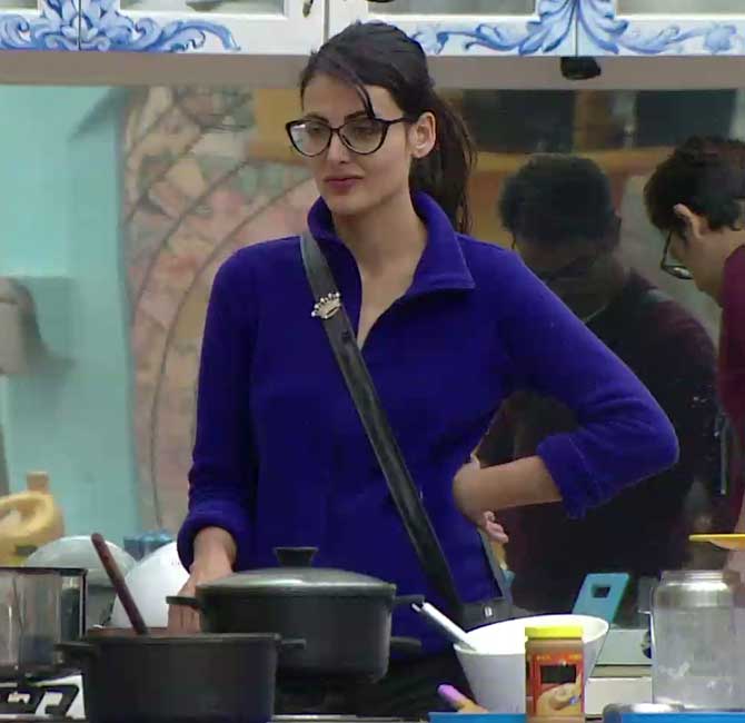 Mandana in the kitchen with dirty utensils in front of her