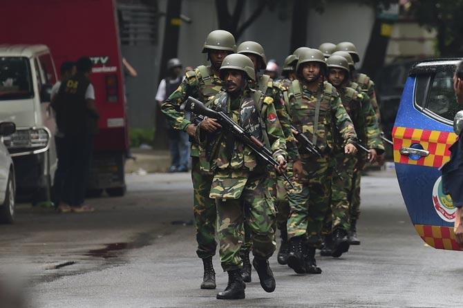 Bangladeshi army soldiers patrol a street during a rescue operation as gunmen take position in a restaurant in the Dhaka