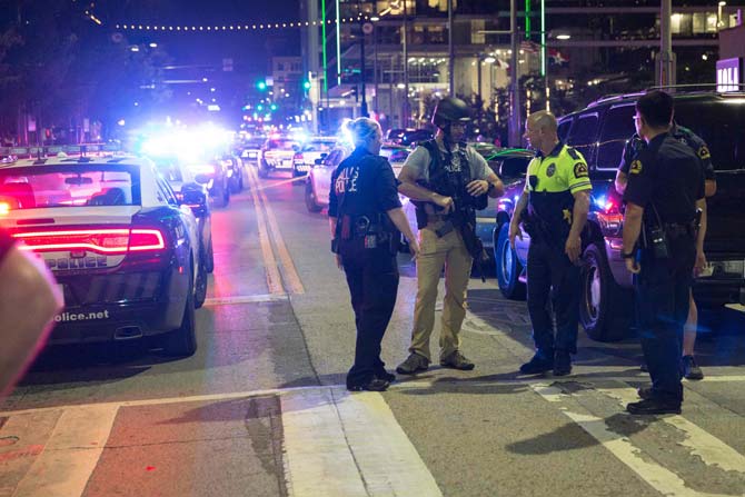 Dallas police officers escort a woman near the scene where Dallas police officers were shot. Pic/ AFP