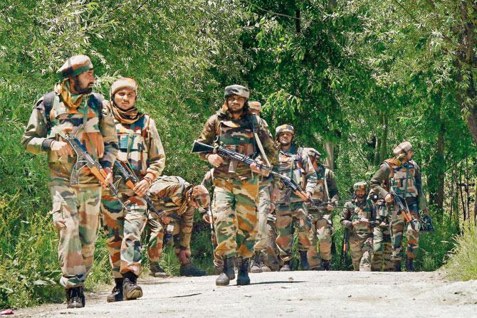 Army Jawans patrol Khonchipora village in Tangmarg following an encounter with the militants. file pic