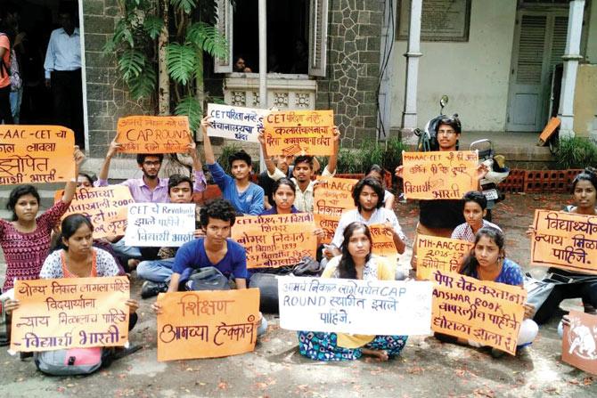 Students protest holding placards condemning the first evaluation process 