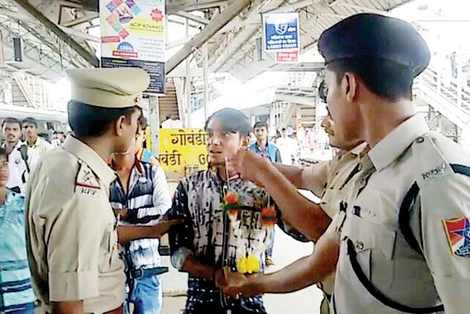 Gandhigiri approach: Cops catch hold of a youngster and garland him after he is caught attempting stunts on a train. 