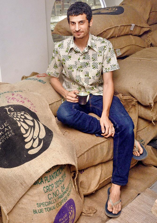 Matt Chitharanjan seated on sacks of coffee beans. PIC/Bipin Kokate