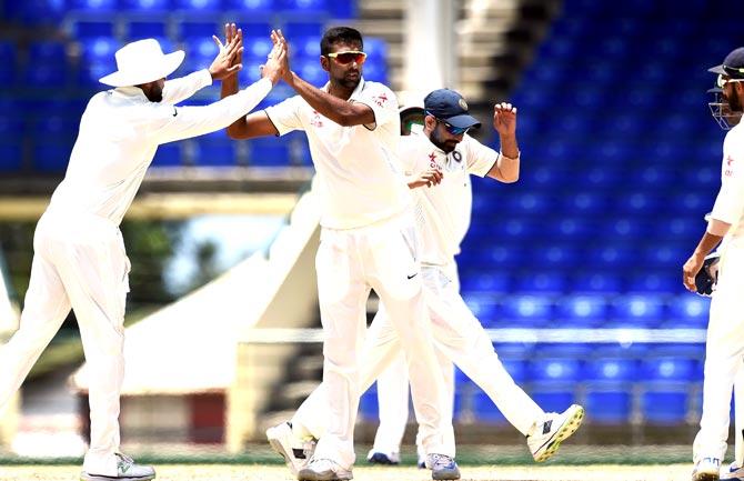Indian cricketer Ravichandran Ashwin (C) celebrates dismissing WICB President