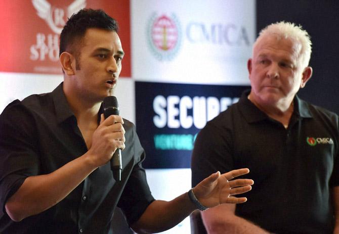 Indian cricketer M S Dhoni speaks after becoming the new global brand ambassador of Secured Venture Capital Company led by former Australian cricketer Craig McDermott (R).