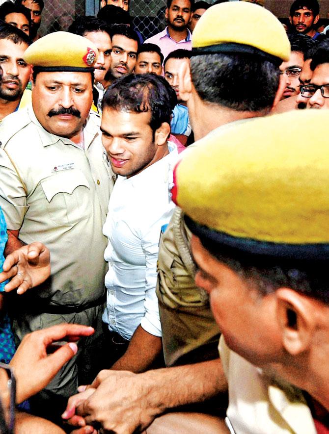 Police personnel escort Narsingh Yadav out of the NADA office in New Delhi yesterday