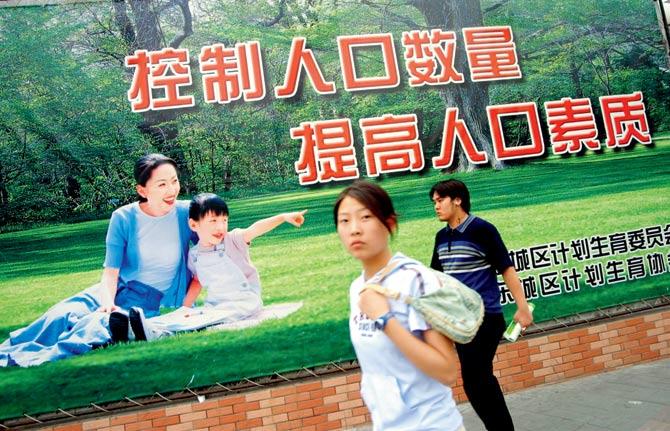 A pedestrian walks past a billboard reading, Control population growth, and raise the quality of the population, in Beijing, China in 2003. In an effort to control the rapid population, the government implemented a single-child policy in the 1970s, aiming to keep the count below 1.6 billion until 2050 with zero population growth. Pic/Getty Images