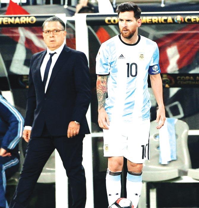 Argentina manager Gerardo Martino (left) watches from the sidelines as Lionel Messi stands on the ball during the Copa America quarter-final vs Venezuela in Massachusetts recently. Pic/Getty Images