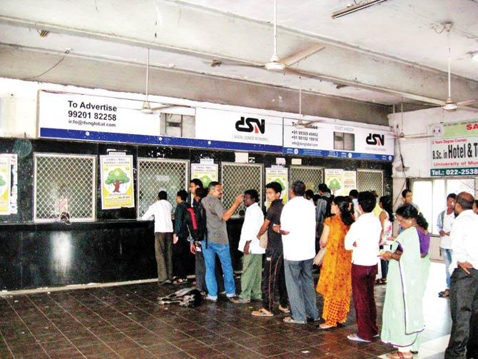 Commuters queue up at a railway ticket counter