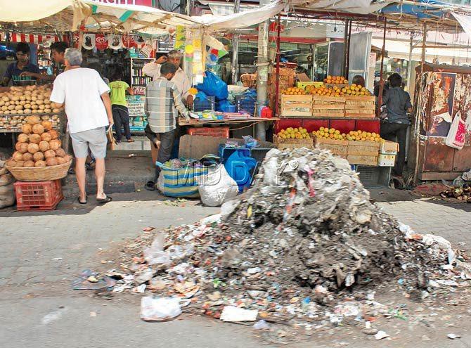A mound of garbage sits in front of fruit and vegetable vendors at Four bungalows, posing a health hazard for everyone. Pics/Tehniyat Fatima