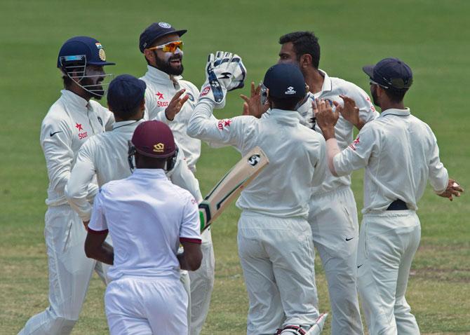 Indian team celebrates the fall of a West Indian wicket during day four of the First Test match. Pic/ AFP