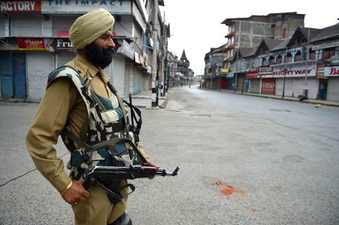 An Indian paramilitary officer stands guard during a curfew in Srinagar