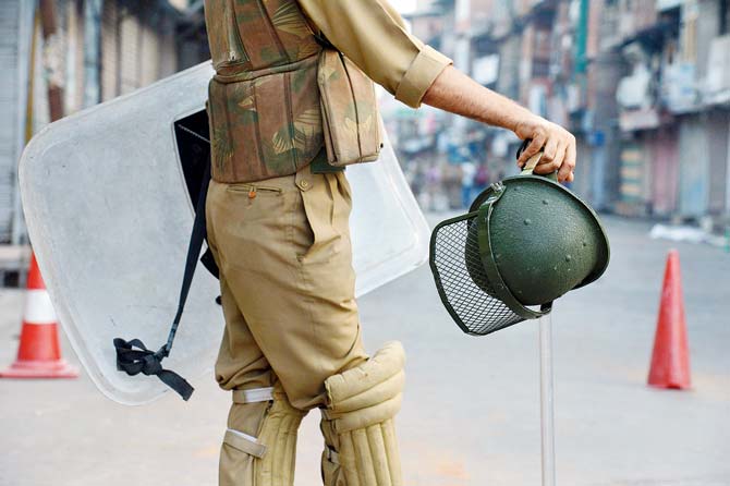 A security official stands guard during a curfew in Srinagar on Monday. Pic/AFP